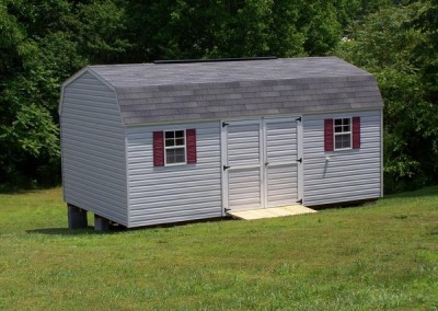12 x 20 V-High Barn with gray siding, white trim, estate gray shingles and maroon shutters, and a treated wooden ramp