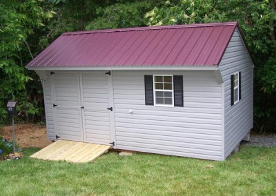 10 x 16 V-Carraige with flint siding and trim, burgundy metal roof and black shutters